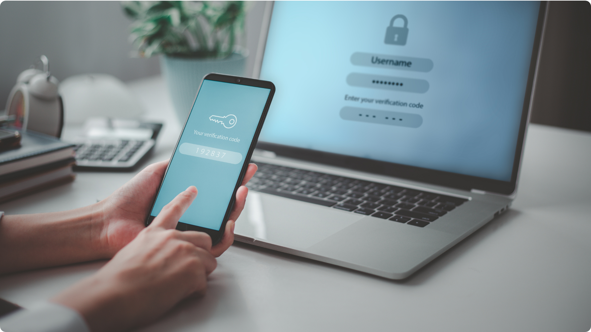 computer and person holding phone with 2fa