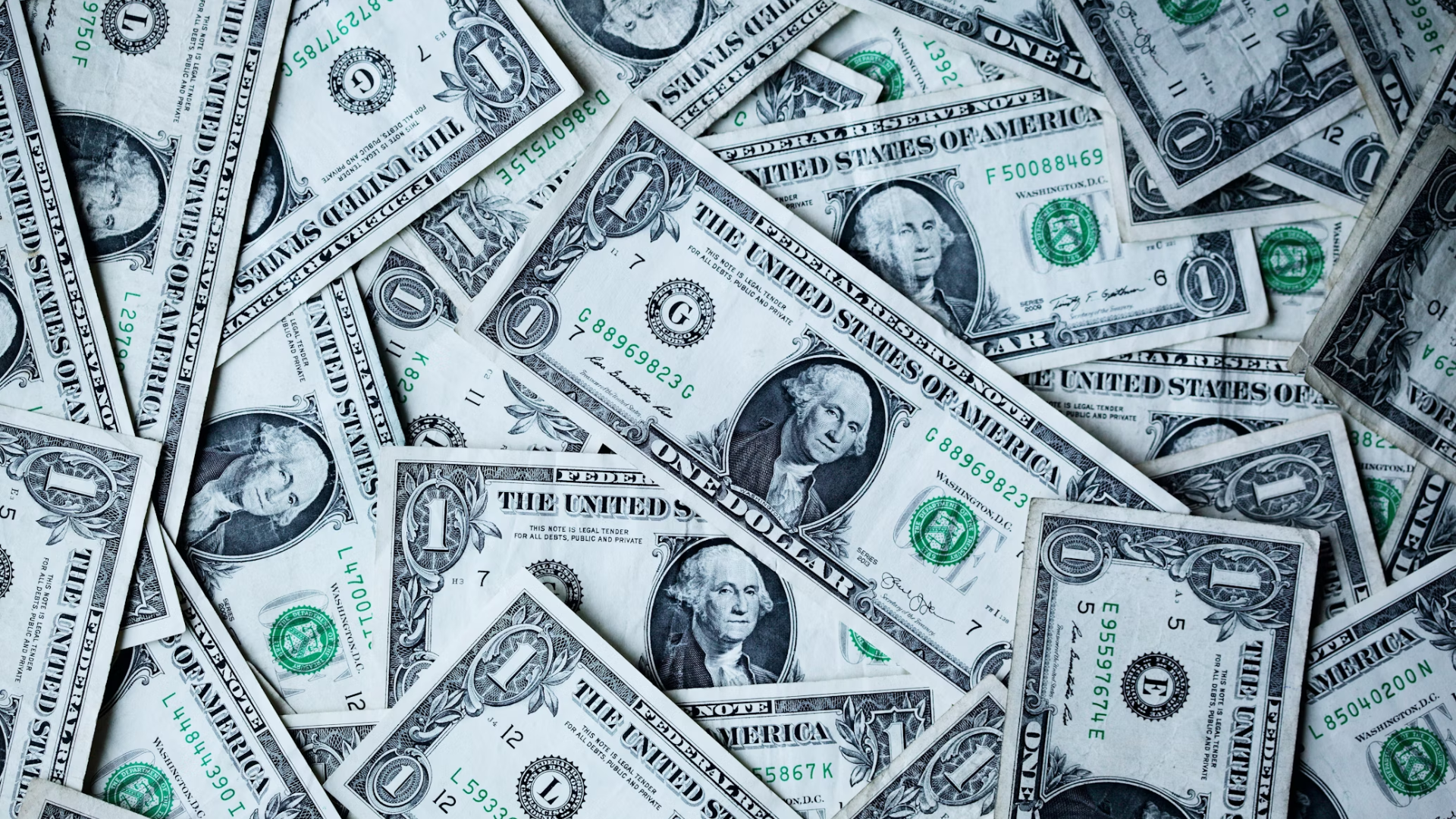 one dollar bills thrown in a pile