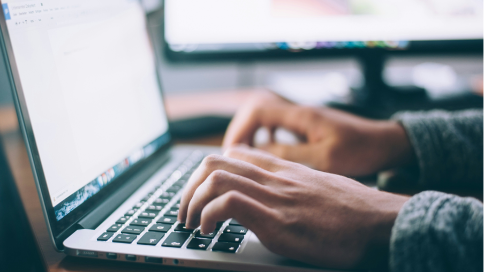 hands typing on laptop